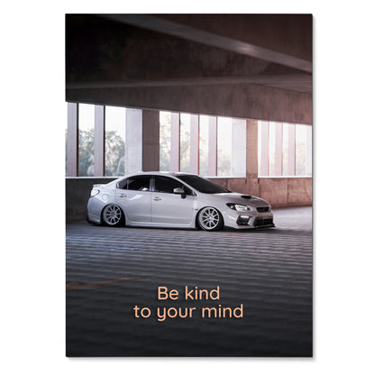 Subaru WRX parked under concrete structure with "Be kind to your mind" motivational text poster wall art.