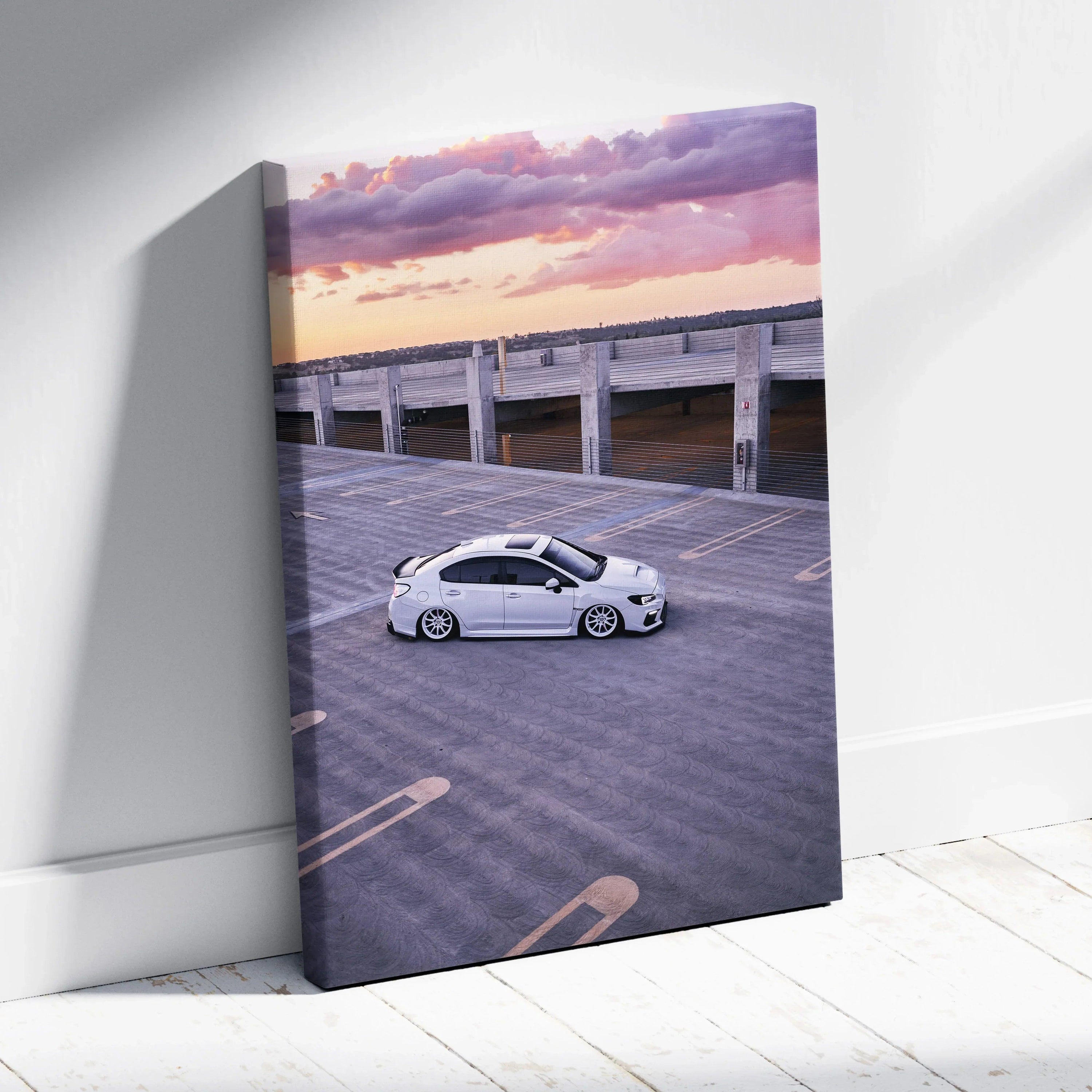 Vertical canvas wall art featuring a white Subaru WRX parked on rooftop at sunset.