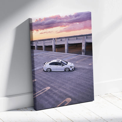 Vertical canvas wall art featuring a white Subaru WRX parked on rooftop at sunset.