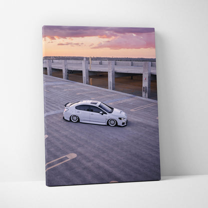 Subaru WRX parked on rooftop at sunset canvas wall art with purple and pink sky.