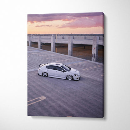 White Subaru WRX parked on rooftop at sunset printed on vertical canvas wall art.