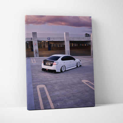 Vertical canvas wall art featuring a white Subaru WRX parked in an urban rooftop setting at sunset.
