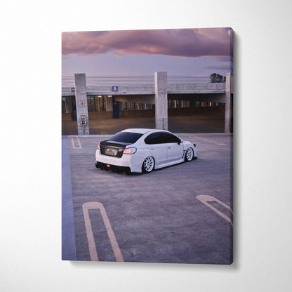 White Subaru WRX parked in rooftop lot at sunset on vertical canvas wall art.