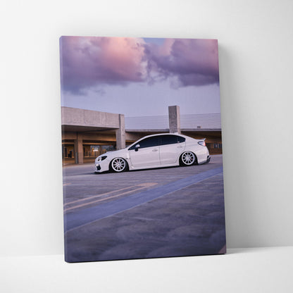 Subaru WRX in white parked at sunset with purple clouds on vertical canvas wall art.
