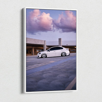 Vertical canvas wall art featuring a white Subaru WRX under a vibrant sunset sky.