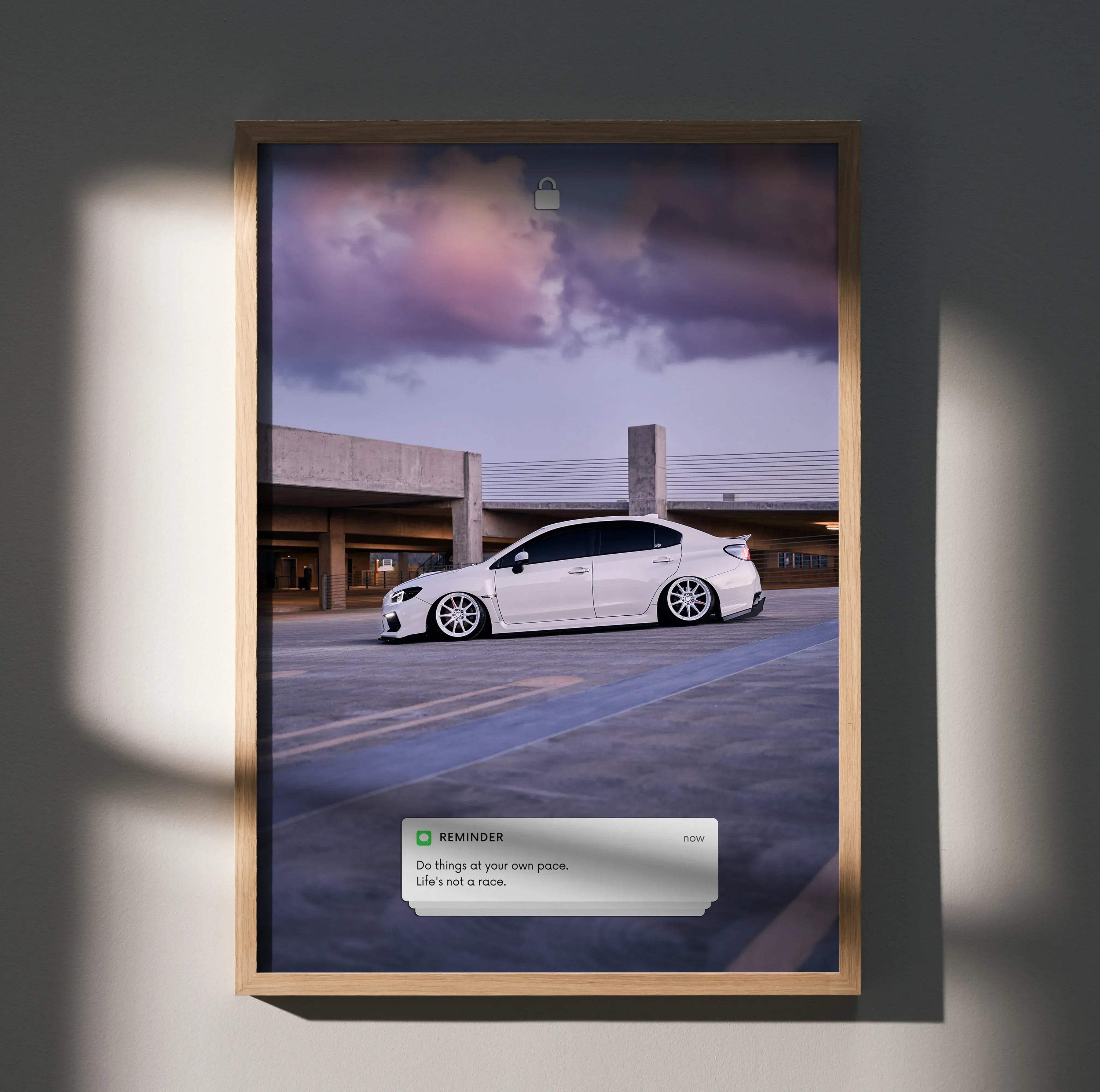 Subaru WRX parked under purple sky with motivational text poster wall art in wooden frame.