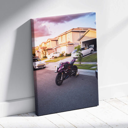 Vertical canvas wall art featuring a BMW S1000RR motorcycle on a suburban street at sunset.