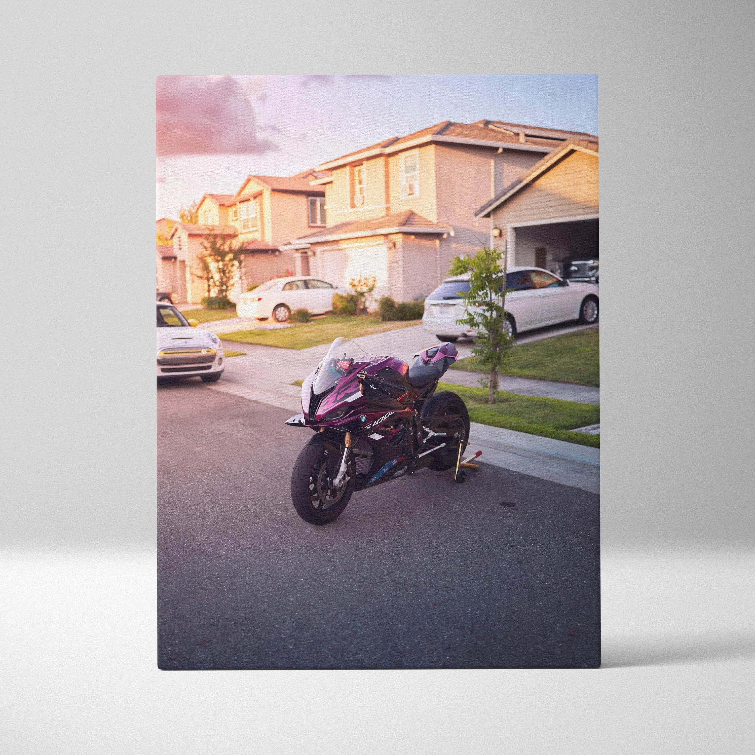 Vertical canvas wall art of a BMW S1000RR motorcycle parked on a suburban street at sunset.