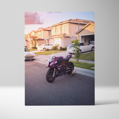 Vertical canvas wall art of a BMW S1000RR motorcycle parked on a suburban street at sunset.