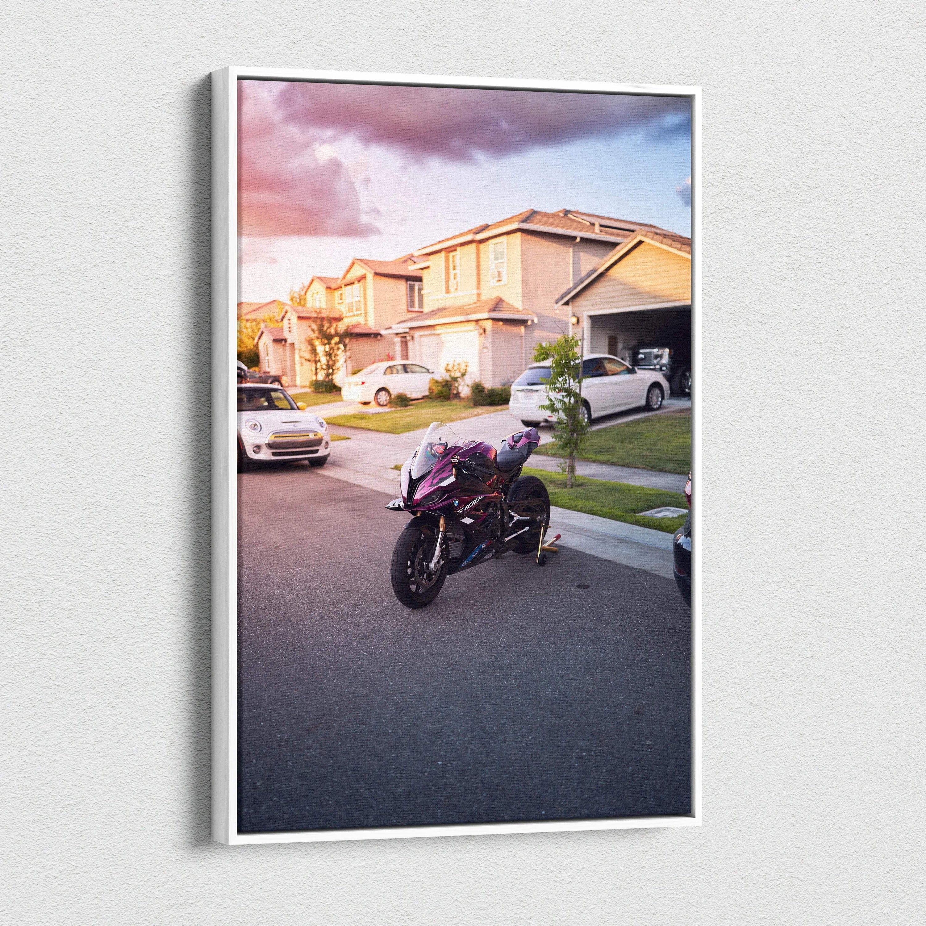 Vertical canvas wall art featuring a BMW S1000RR motorcycle parked on a suburban street at sunset.