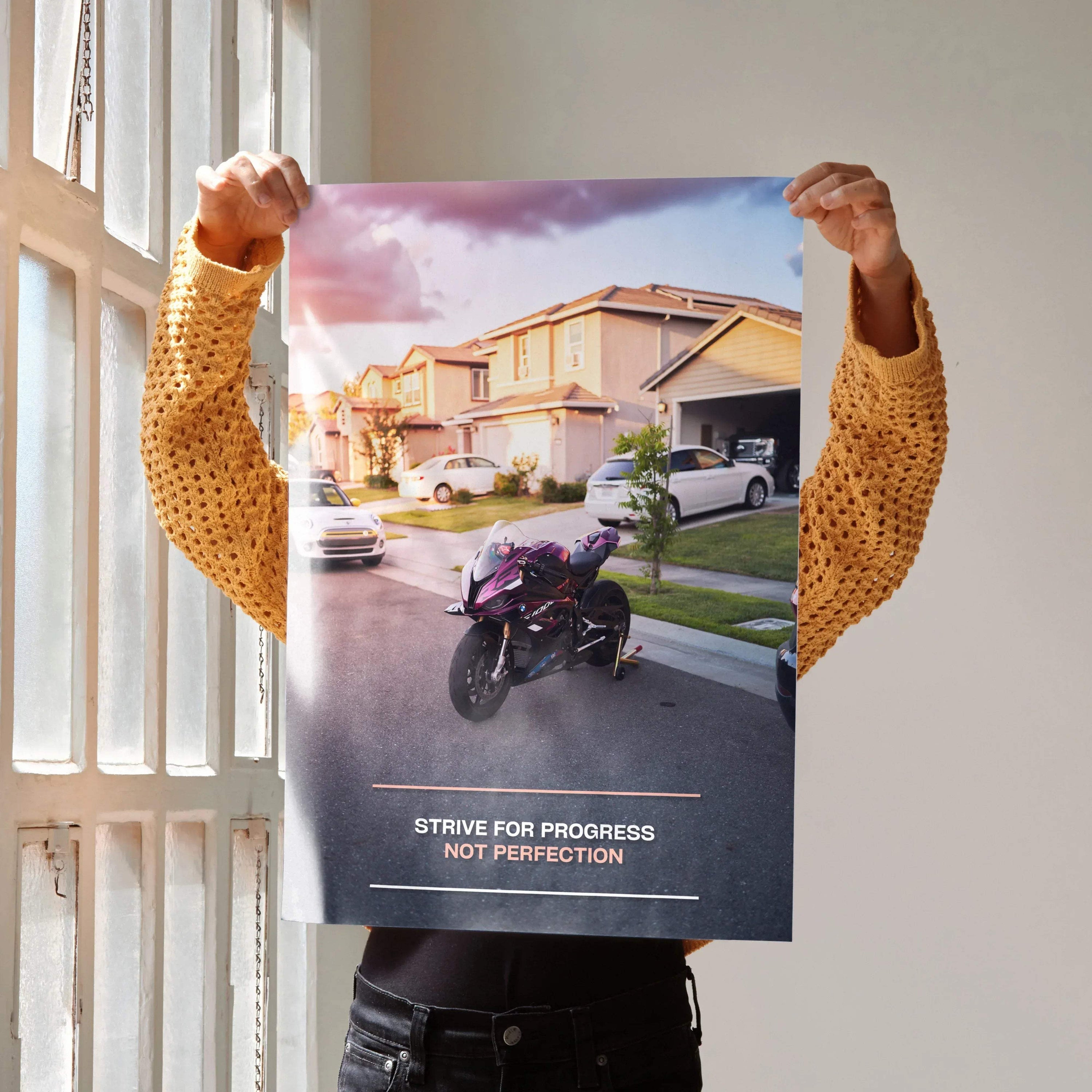Motivational poster wall art featuring a BMW S1000RR motorcycle with inspiring text in a suburban street setting.