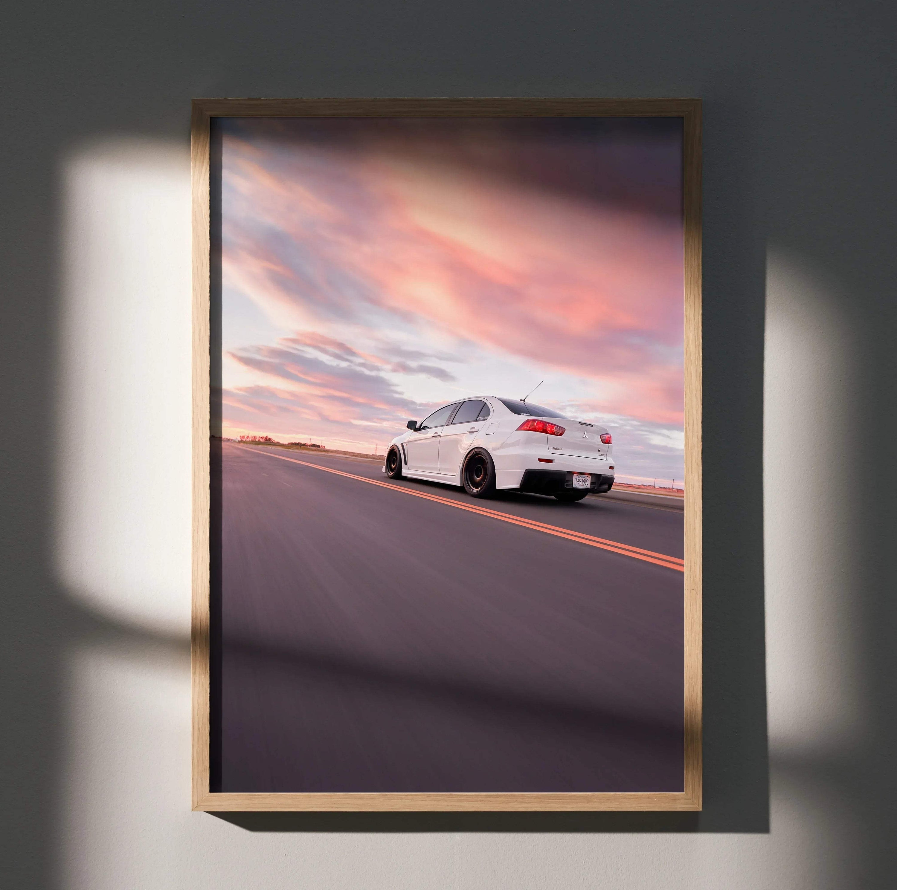 Mitsubishi Evo 10 driving on road at sunset vibrant sky poster wall art in wooden frame.
