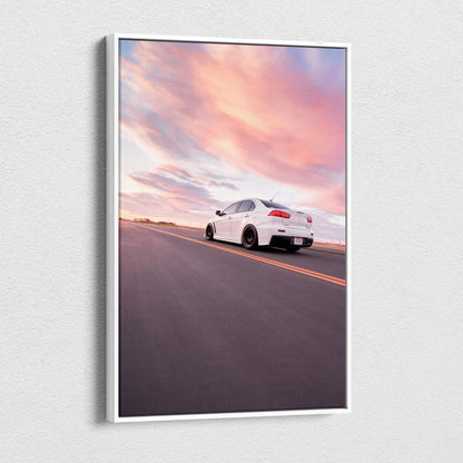 Vertical canvas wall art featuring a white Mitsubishi Evo 10 on an open road under a colorful sunset sky.