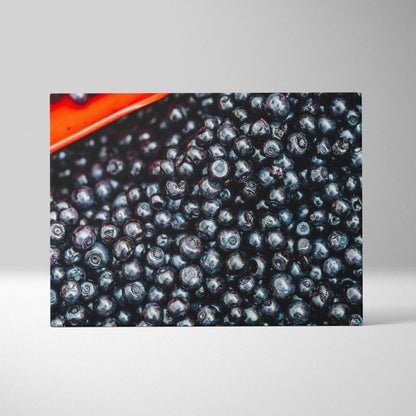 Canvas wall art featuring a close-up of vibrant, glossy blueberries with rich blue and purple hues and a hint of red corner.