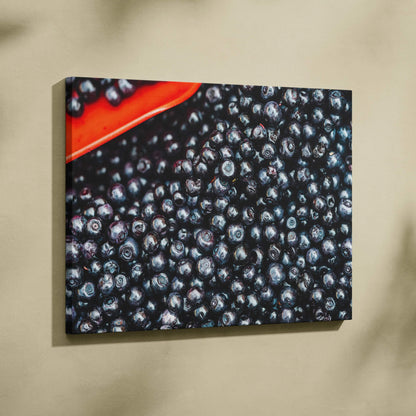 Canvas wall art featuring a close-up of vibrant, glossy blueberries with a pop of red in the corner for home decor.