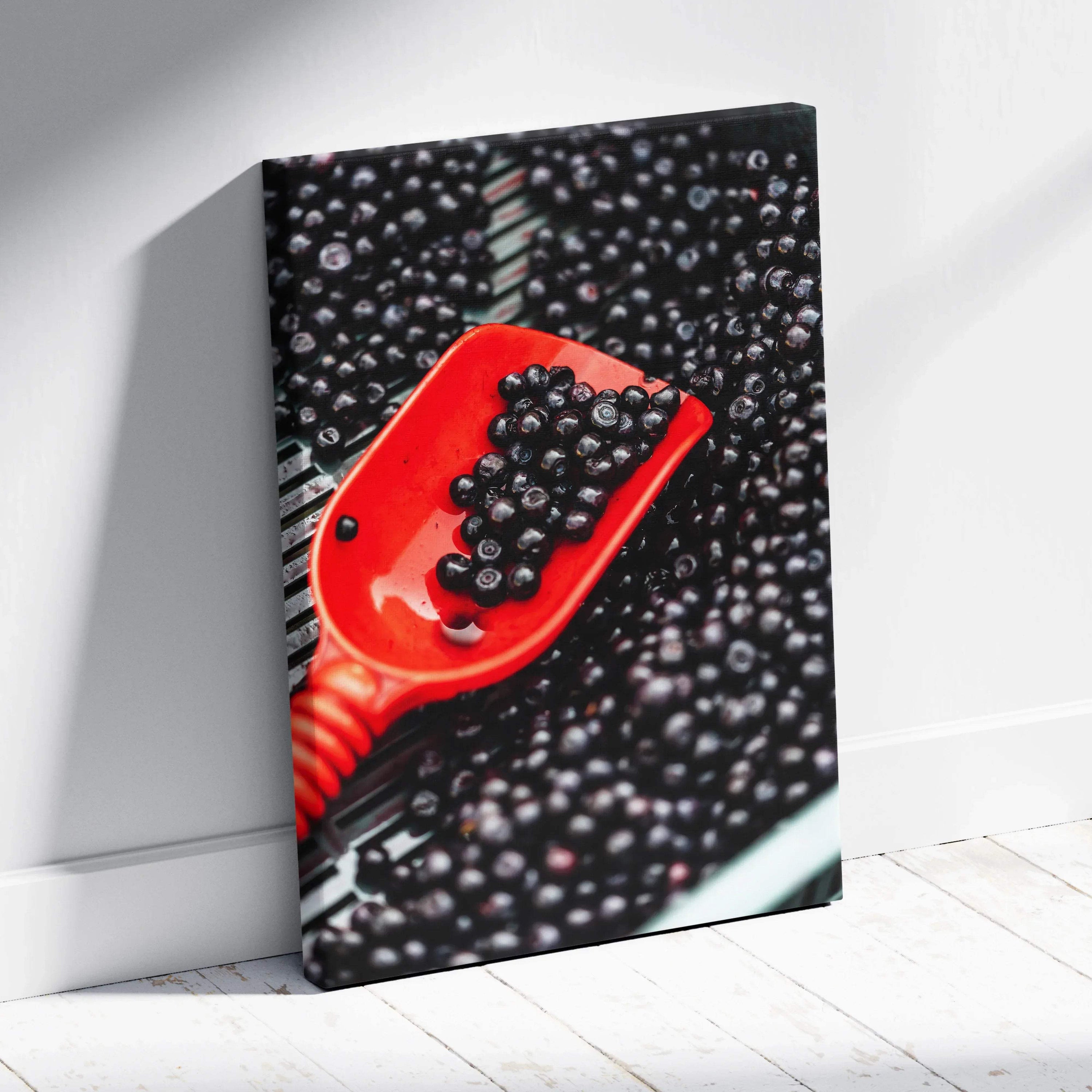 Canvas wall art featuring a vibrant close-up of glossy blueberries on a bright red spoon against a dark background.