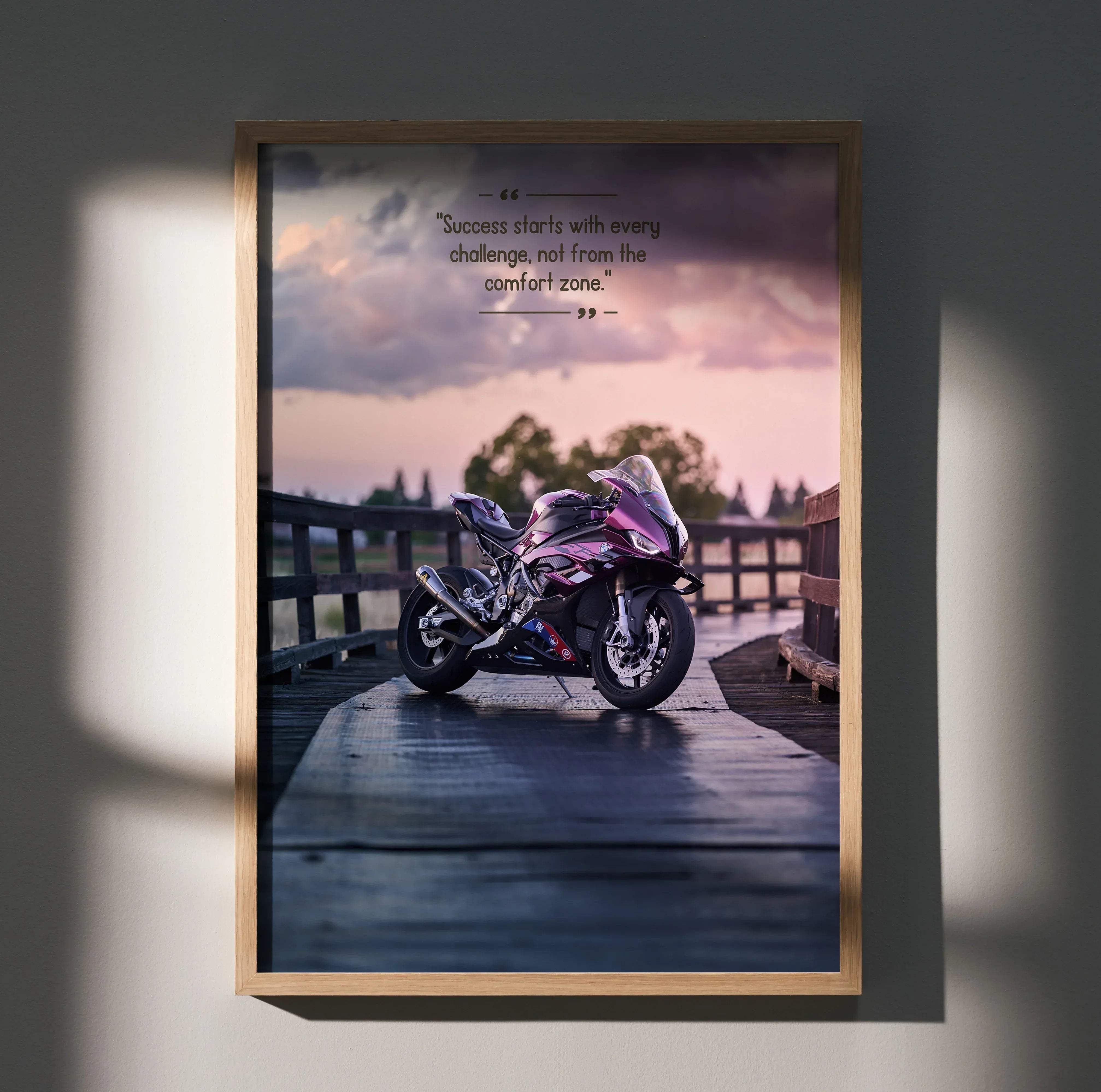 A framed motivational poster featuring a sleek metallic purple and black BMW S1000RR sport motorcycle on a wooden bridge