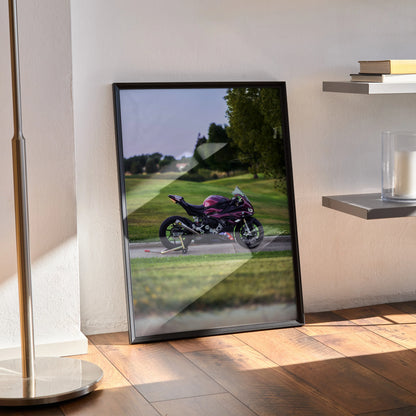 BMW S1000RR motorcycle poster with vibrant purple bike against scenic green landscape wall art in black frame.