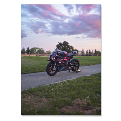BMW S1000RR motorcycle parked on pathway during sunset Poster Wall Art with colorful sky background.