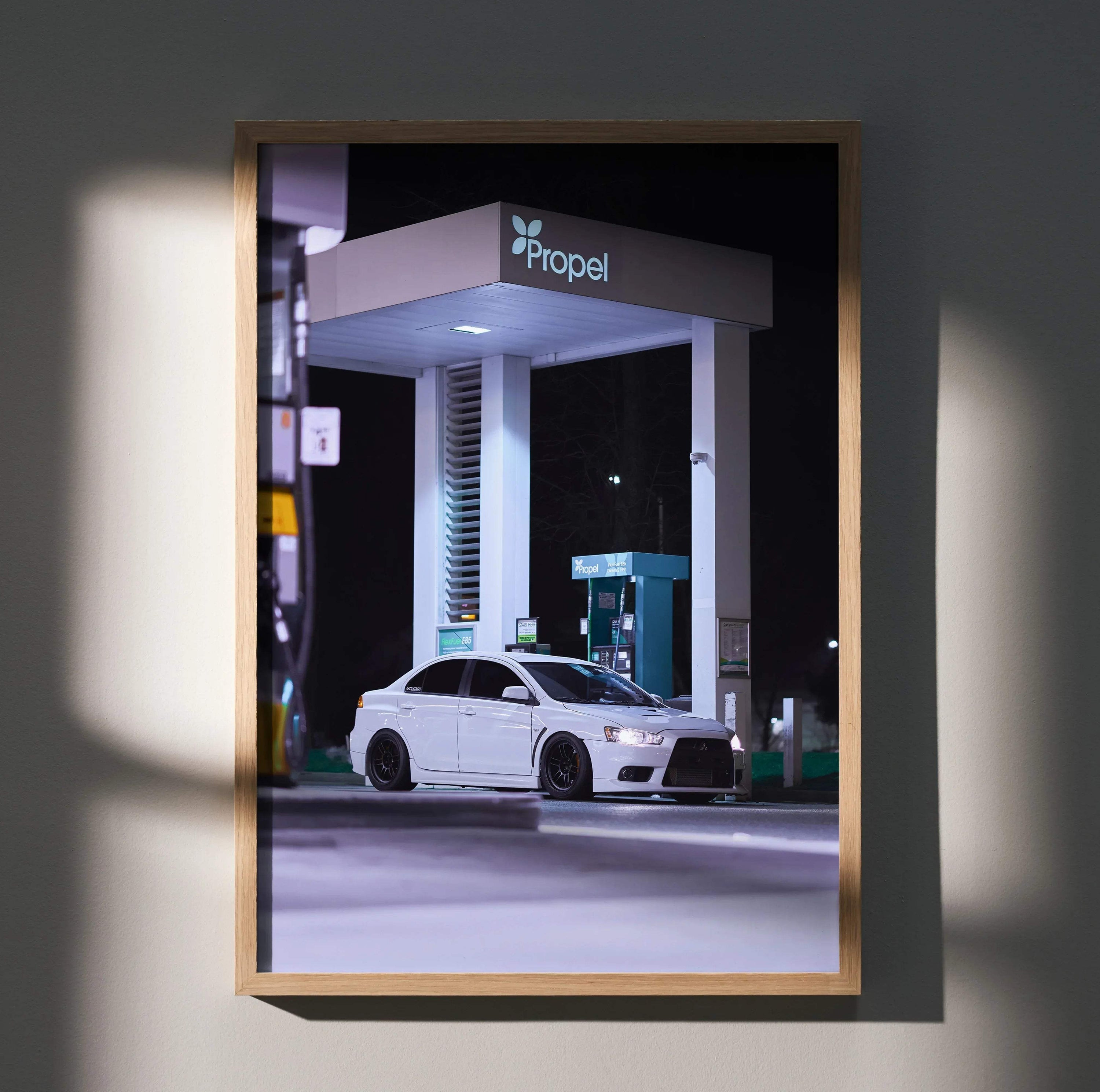 Mitsubishi Evo 10 poster wall art featuring a white car parked under a lit gas station canopy at night.
