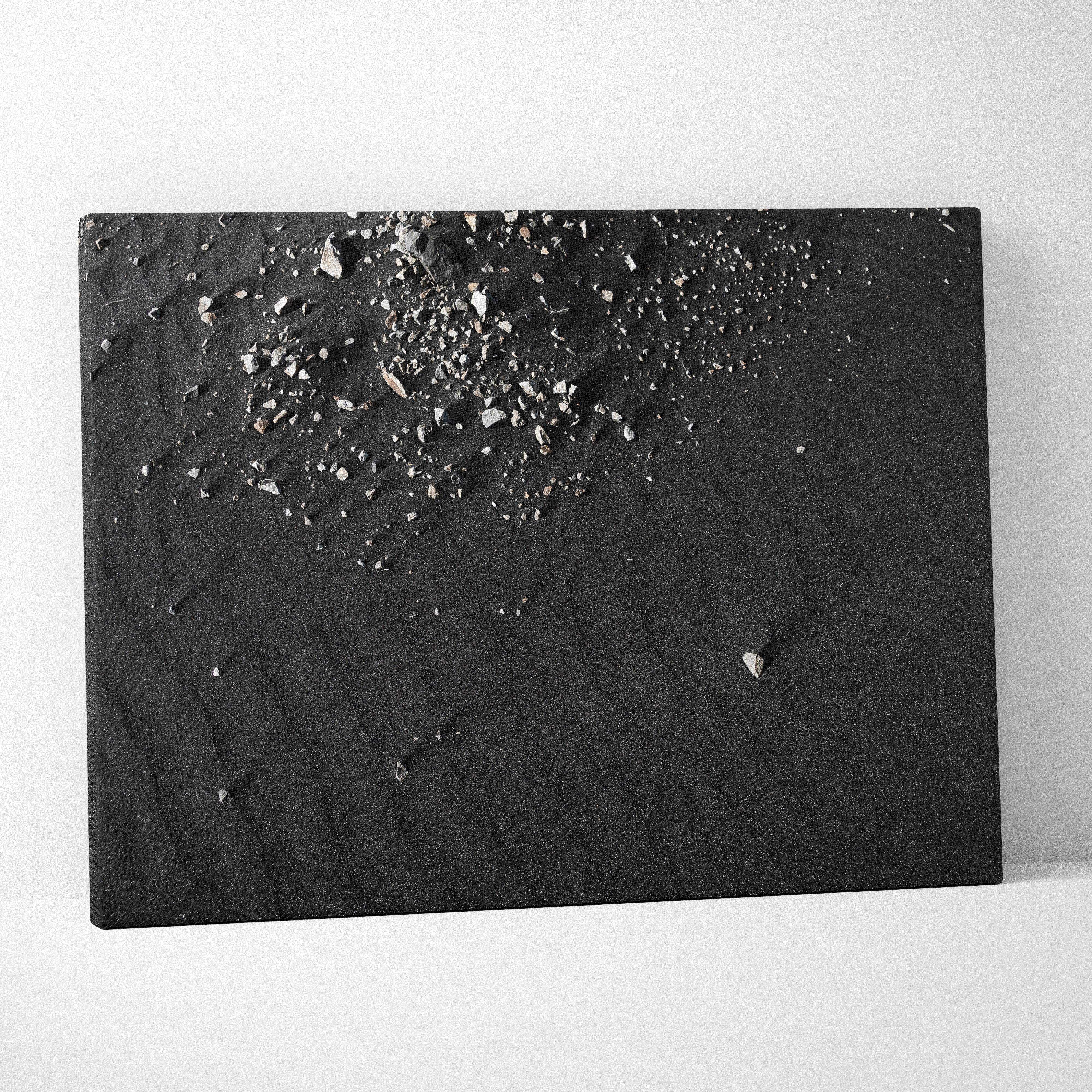 Black canvas print with moody gray textured surface and scattered silver-gray pebble fragments for modern decor