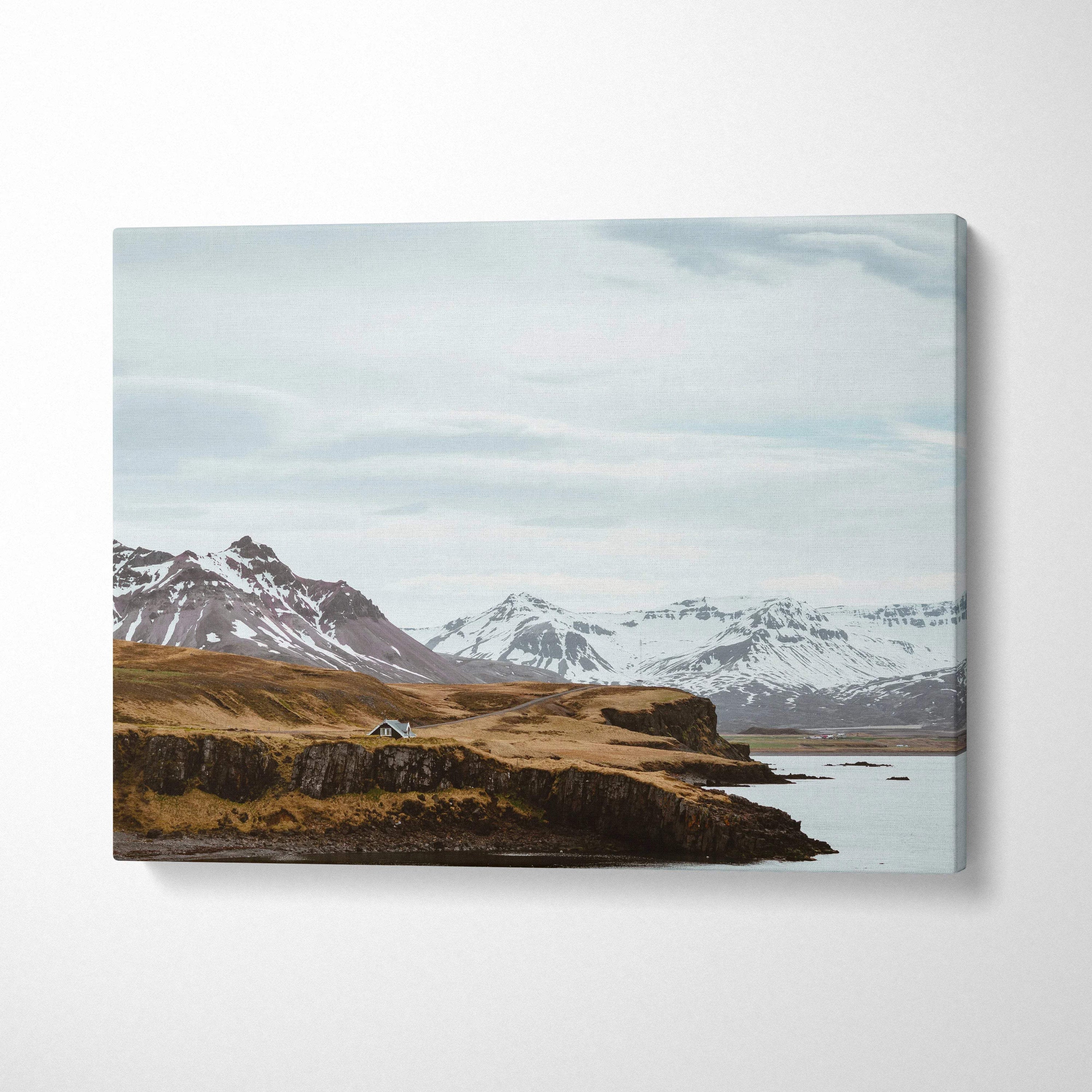 Canvas print of Nordic Icelandic snowy mountain coastline with cabin