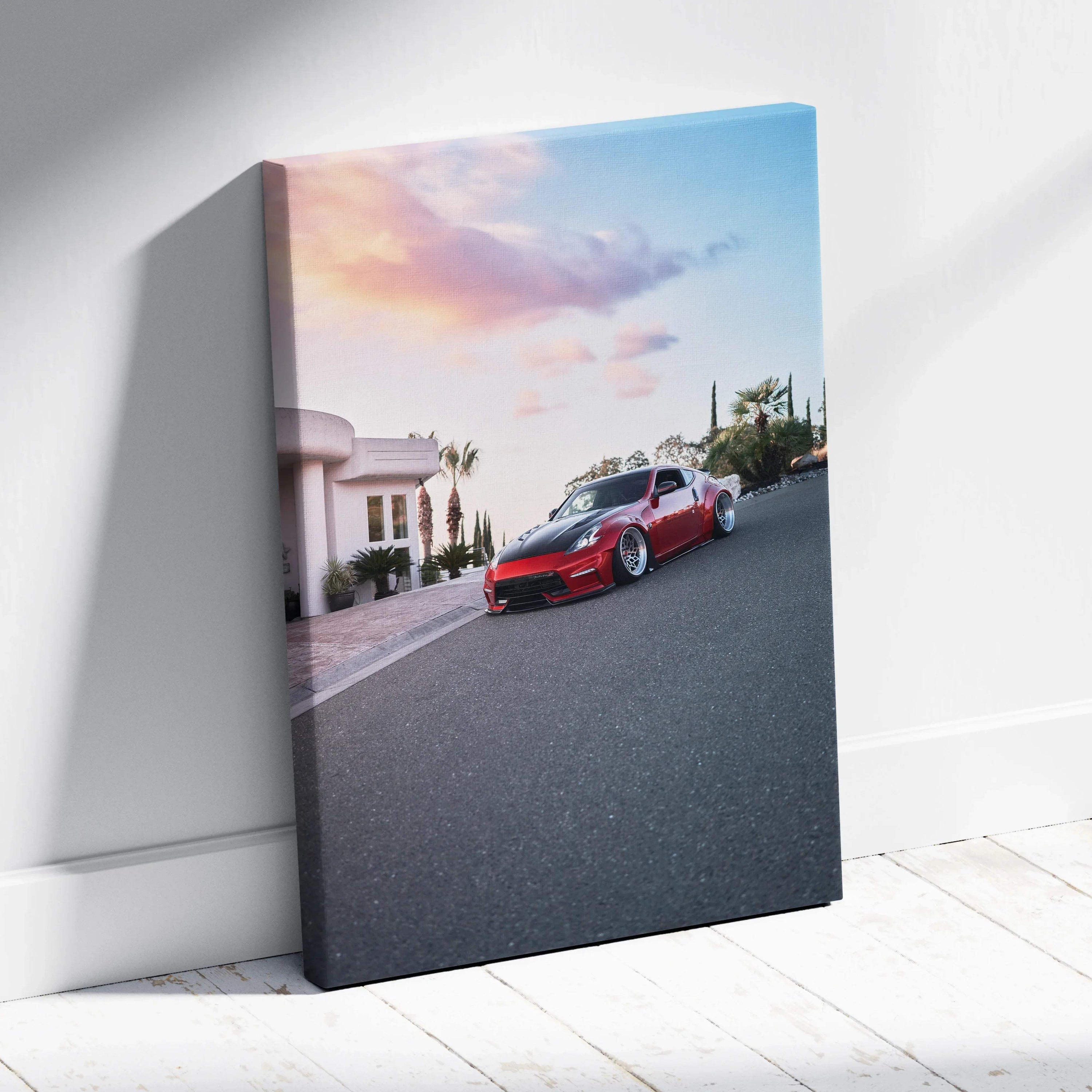 Vertical canvas wall art featuring a red Nissan 370z on a street at sunset with a colorful sky.