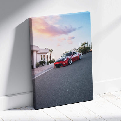 Vertical canvas wall art featuring a red Nissan 370z on a street at sunset with a colorful sky.
