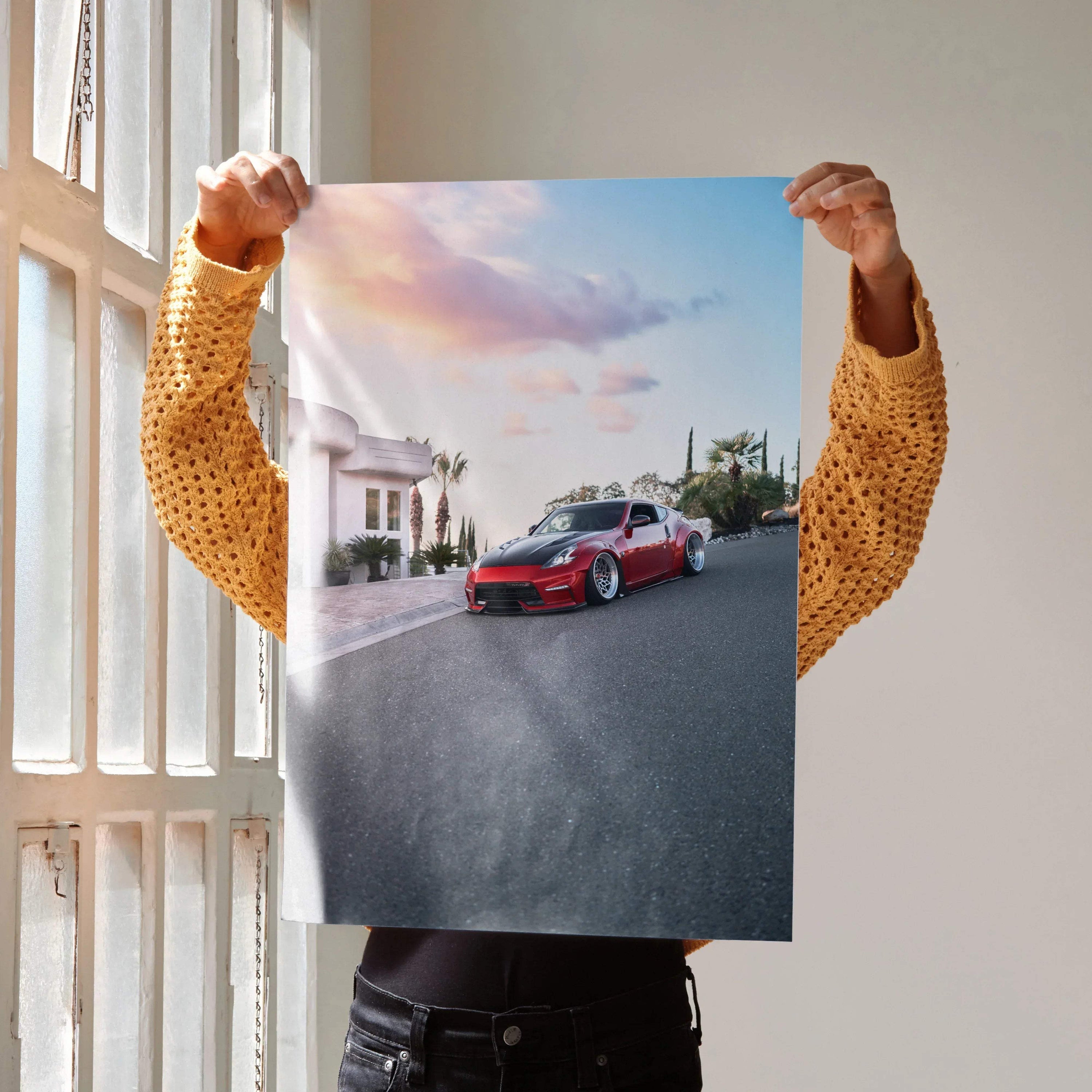 Nissan 370z poster wall art showing red sports car on street at sunset under colorful sky.