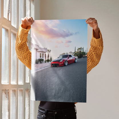 Nissan 370z poster wall art showing red sports car on street at sunset under colorful sky.