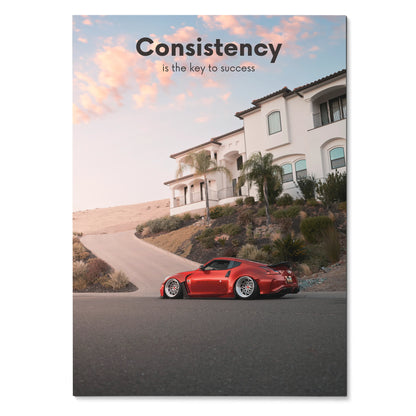 Poster wall art featuring a red Nissan 370z parked on a residential street under a pink sky with the text "Consistency is.