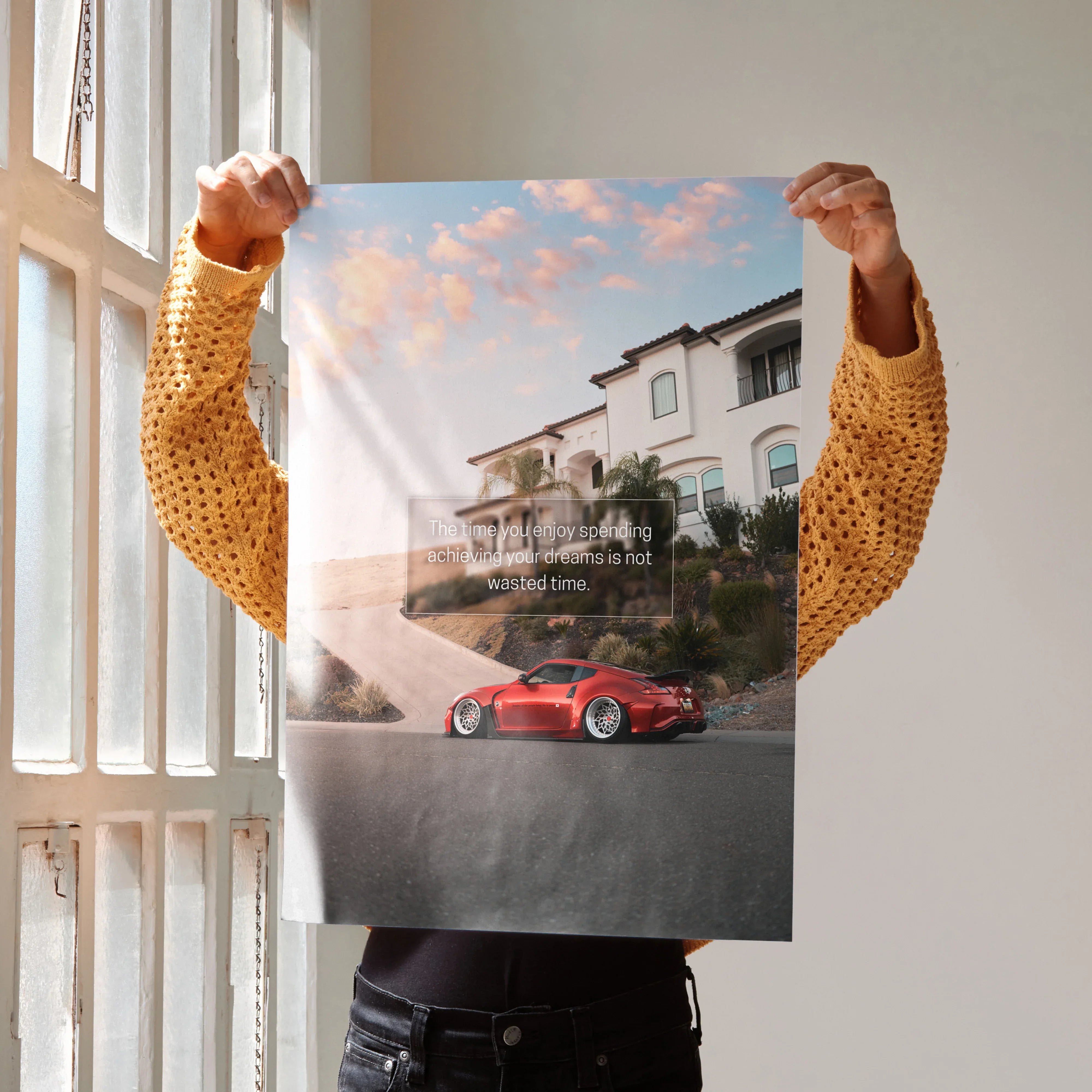 Poster wall art featuring a red Nissan 370z on a coastal road with inspiring quote and sunset sky.
