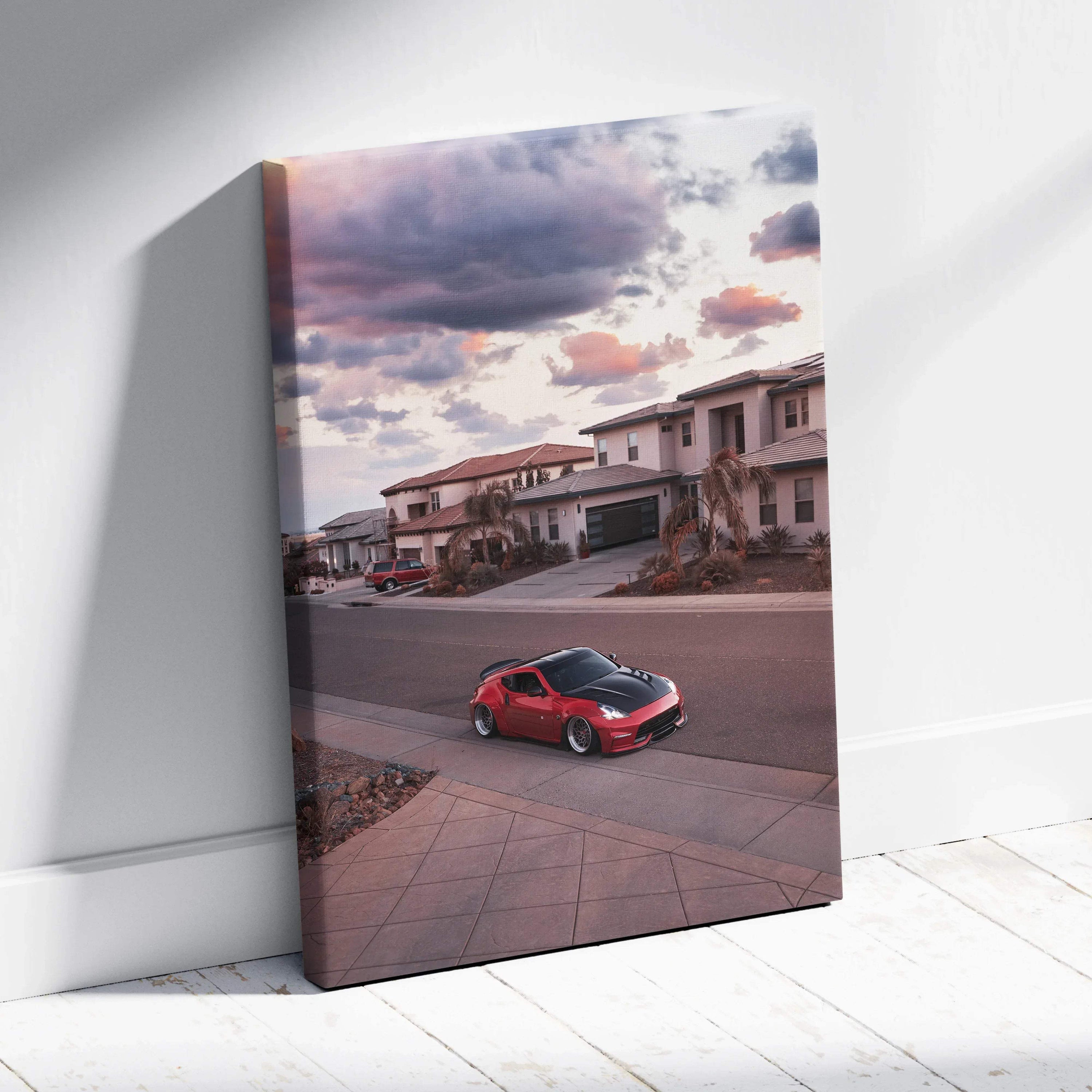 Red Nissan 370z driving through suburban street at sunset on vertical canvas wall art.