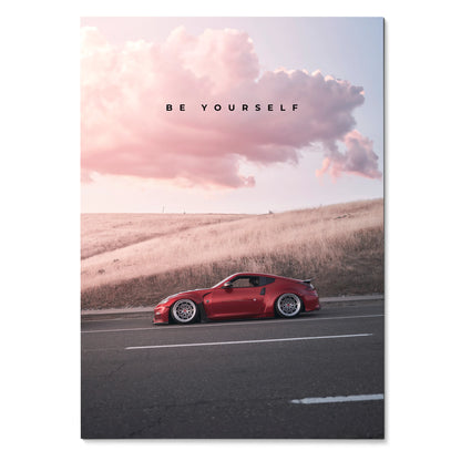 Poster wall art featuring a red Nissan 370z on a road under a pink sky with "Be Yourself" text.
