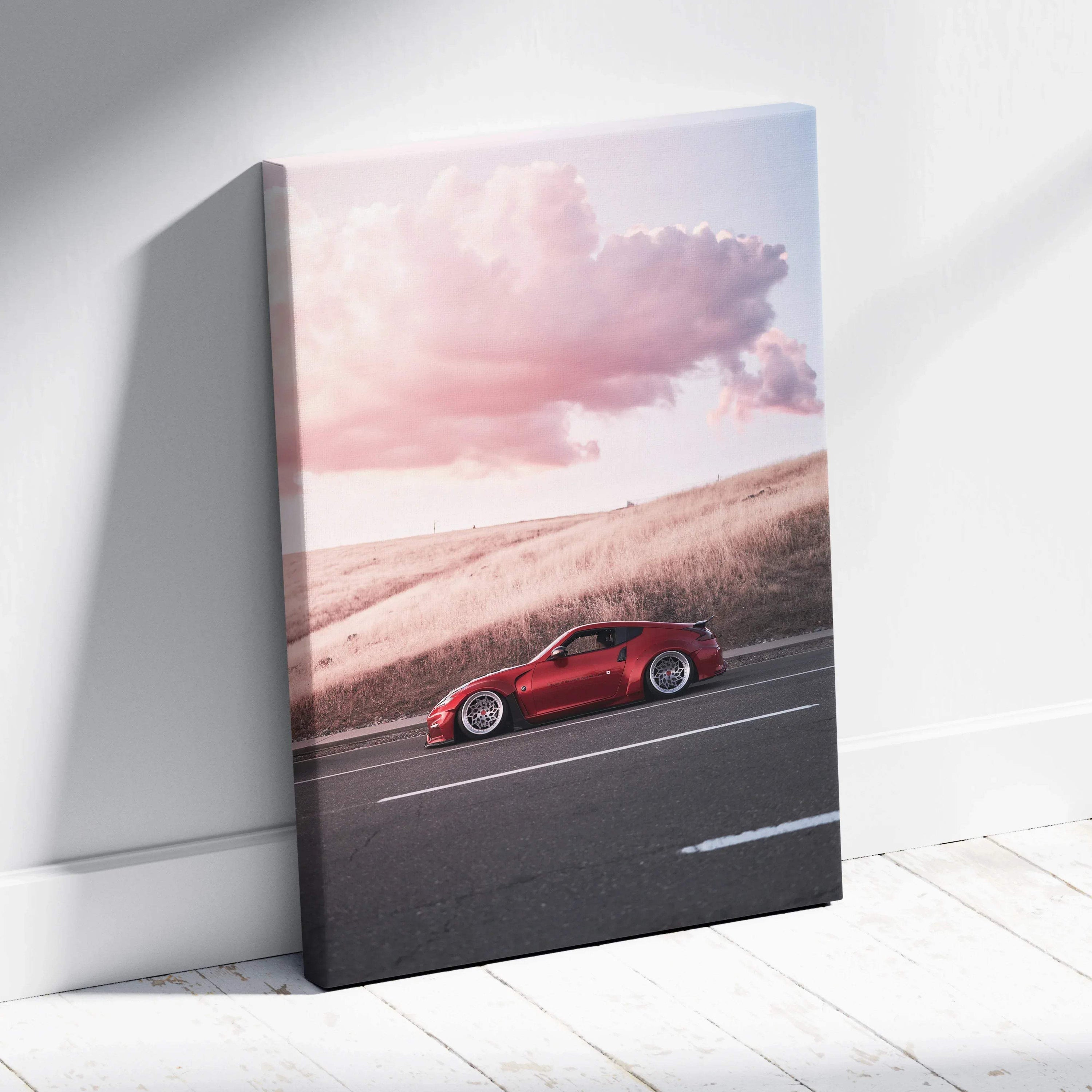 Vertical canvas wall art featuring a red Nissan 370z driving at sunset with pink clouds.