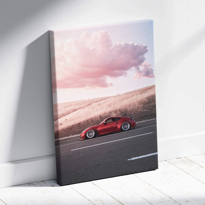 Vertical canvas wall art featuring a red Nissan 370z driving at sunset with pink clouds.
