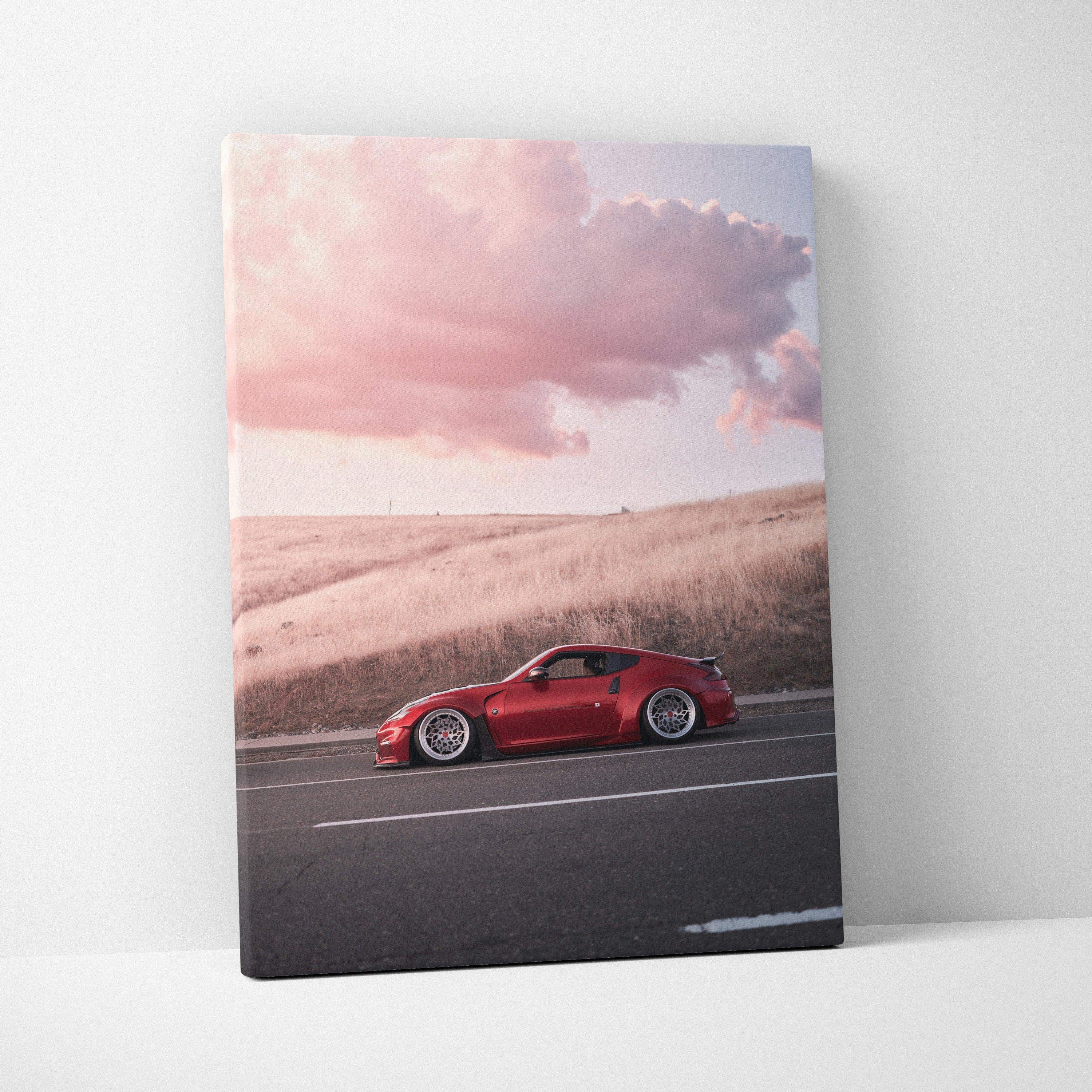 Red Nissan 370z on highway at sunset with dramatic clouds canvas wall art.