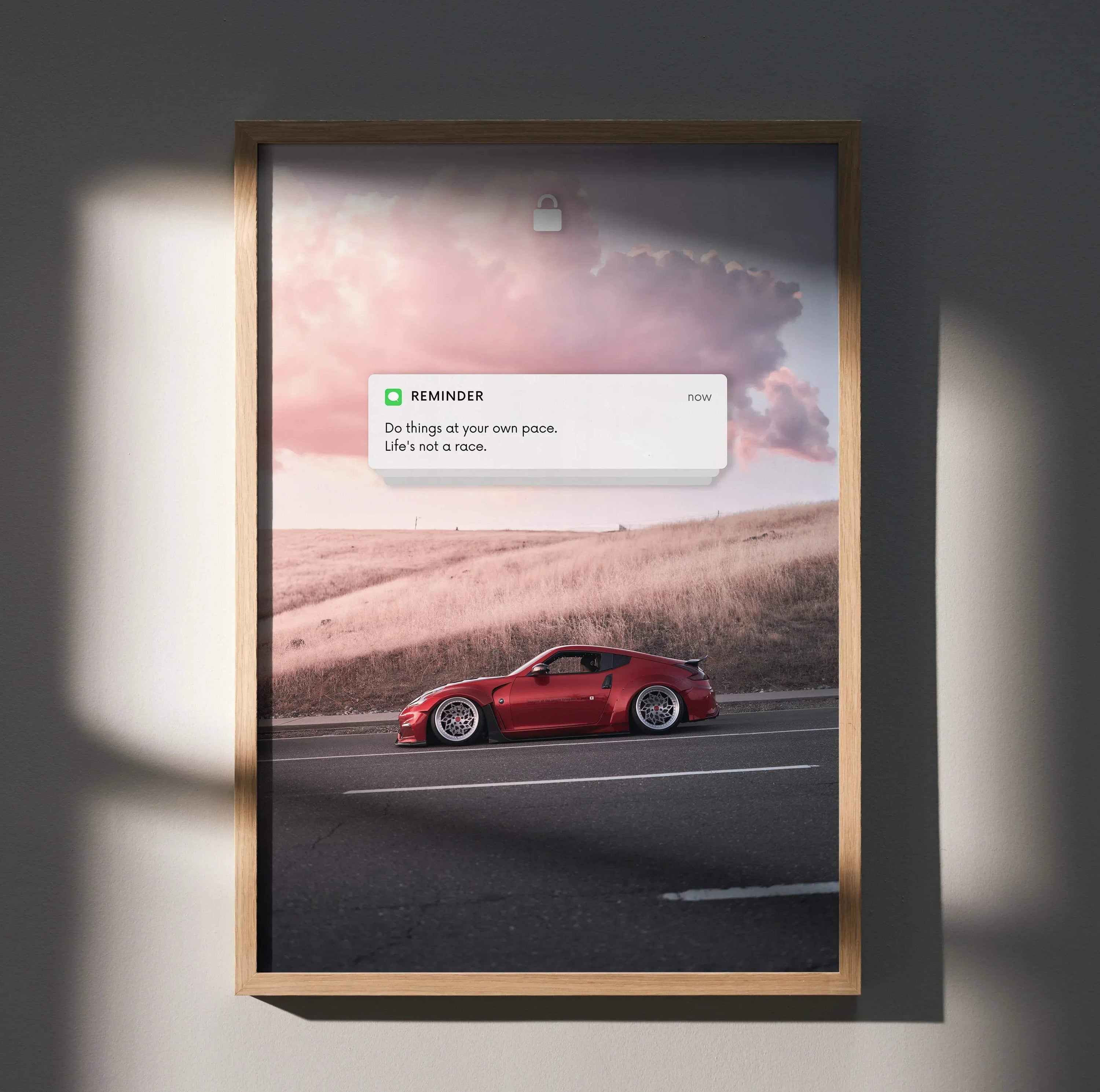 Red Nissan 370z driving on road with motivational reminder text poster wall art.
