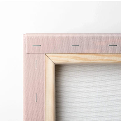 Close-up of pink stretched canvas and natural wood frame corner for vertical wall art.