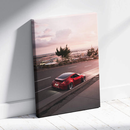 Red Nissan 370z driving on road at sunset canvas wall art print.