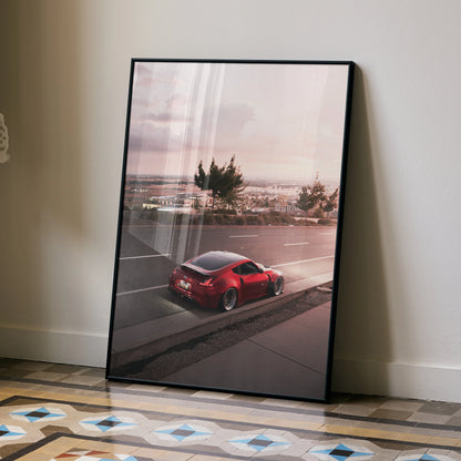 Nissan 370z poster wall art featuring red sports car parked near water at sunset with soft pastel sky.