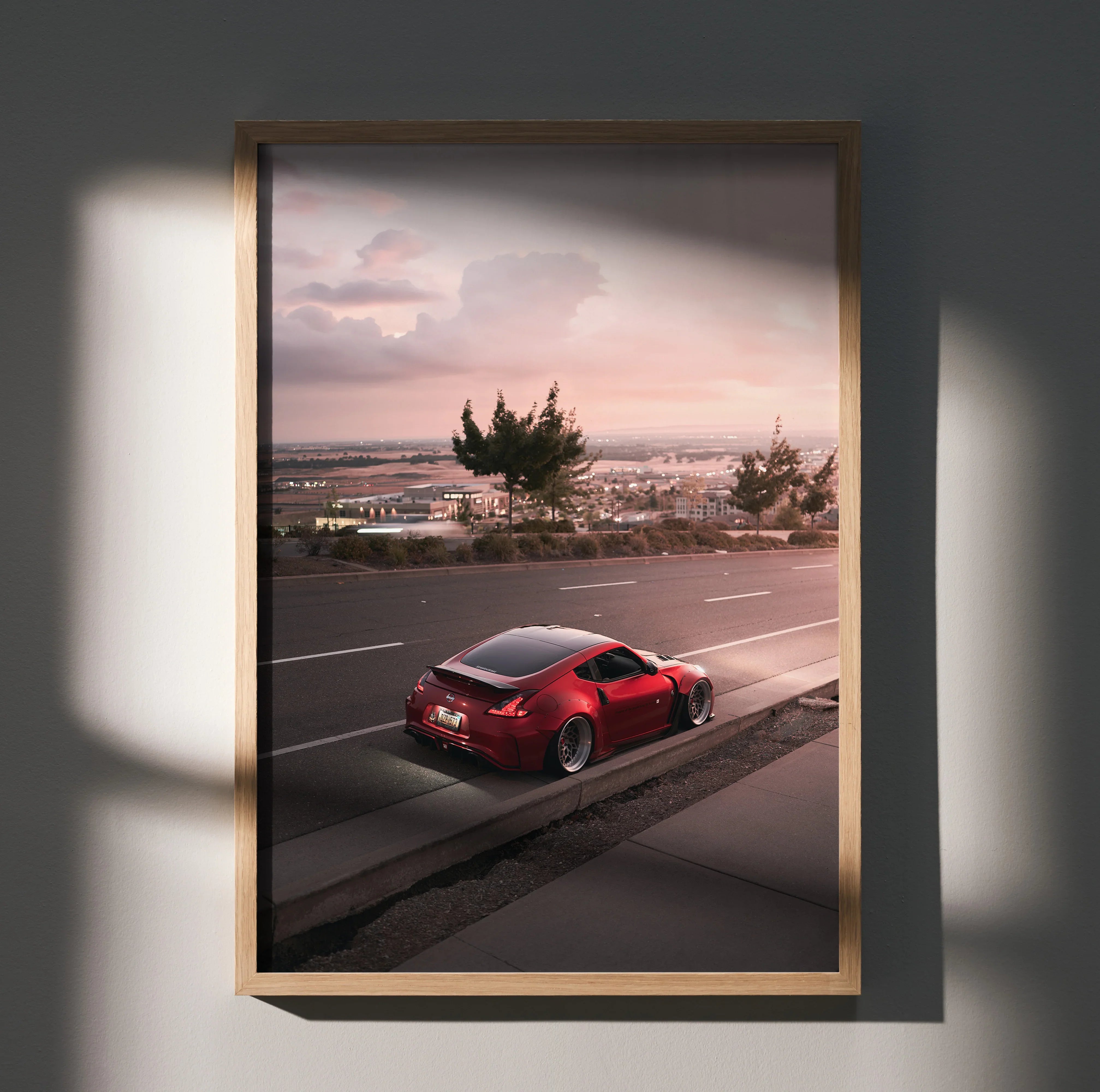 Nissan 370z red sports car driving at sunset poster wall art in wooden frame.