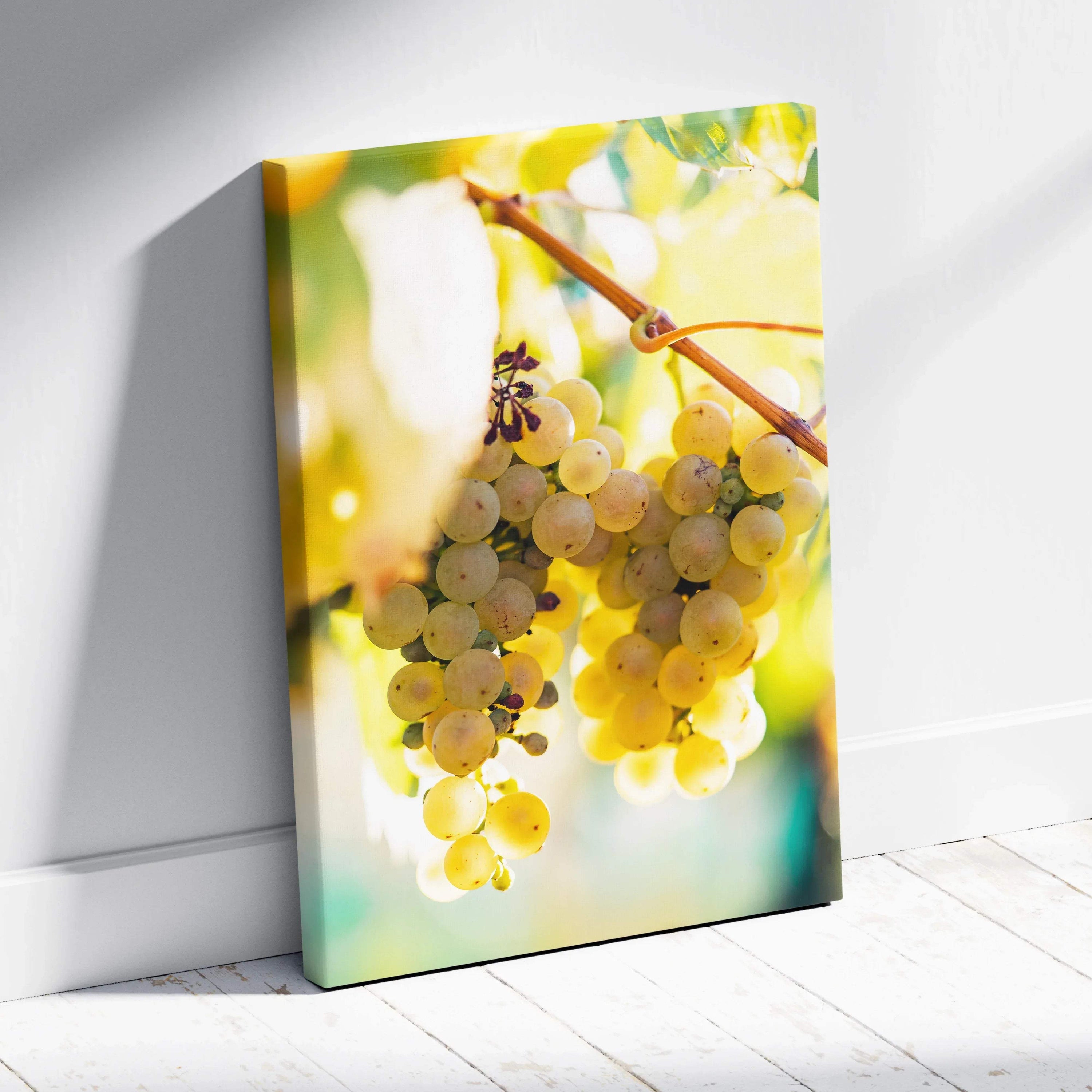 Vertical canvas wall art featuring vibrant yellow-green grape cluster with sunlight and soft-focus leaves in background,.
