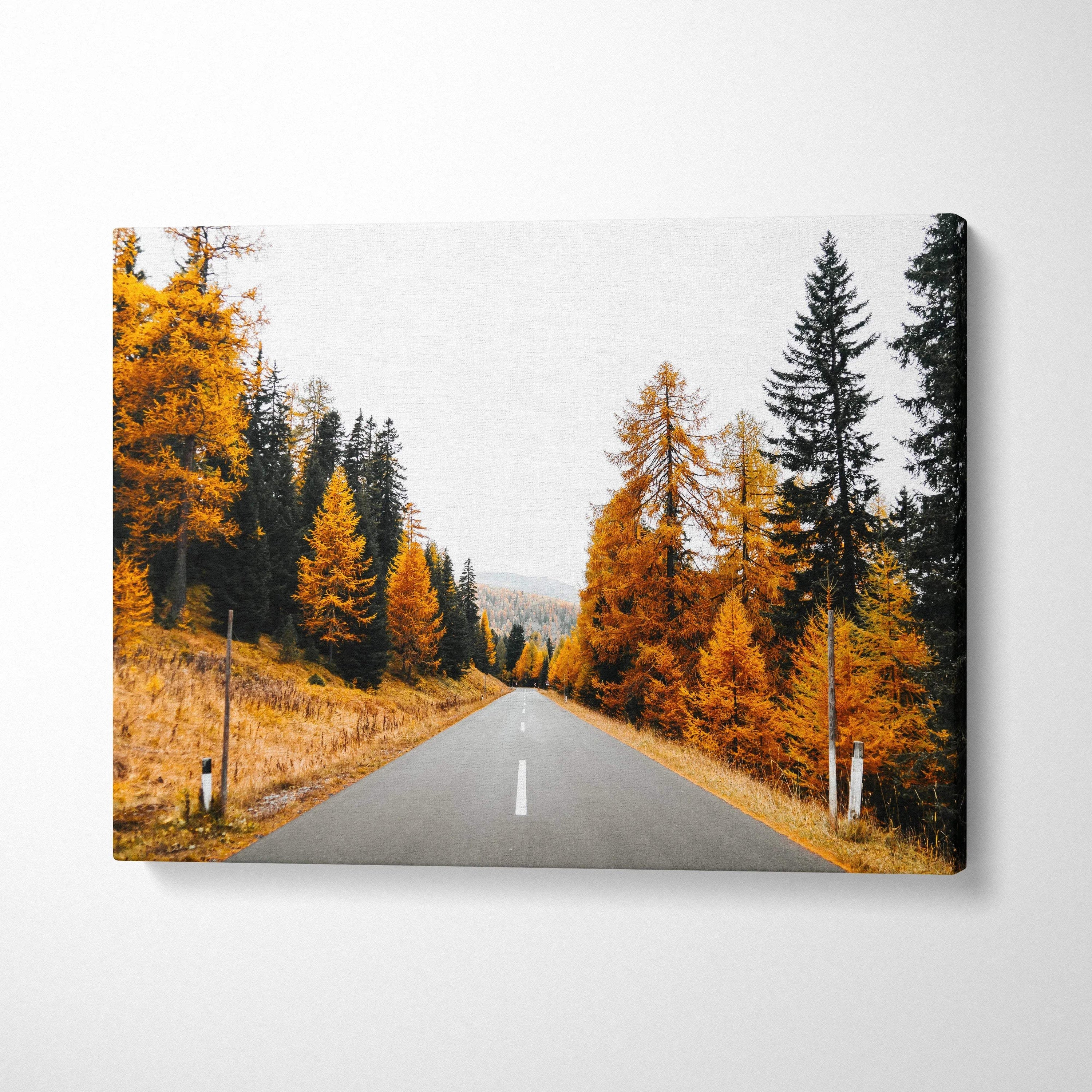 Autumn road lined with vibrant orange and yellow trees on canvas wall art print.