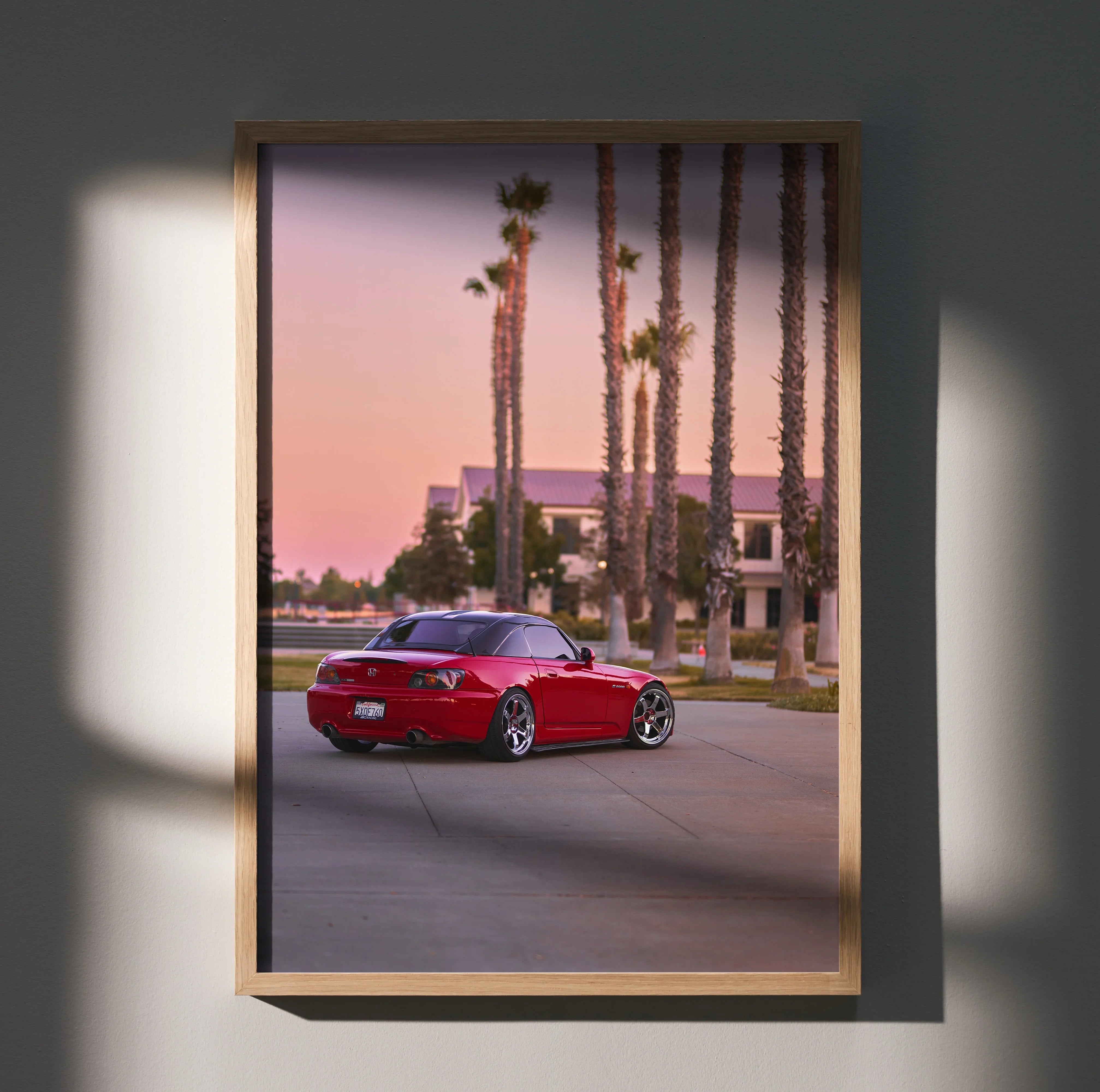 Red Honda S2000 parked on street at sunset with palm trees poster wall art.