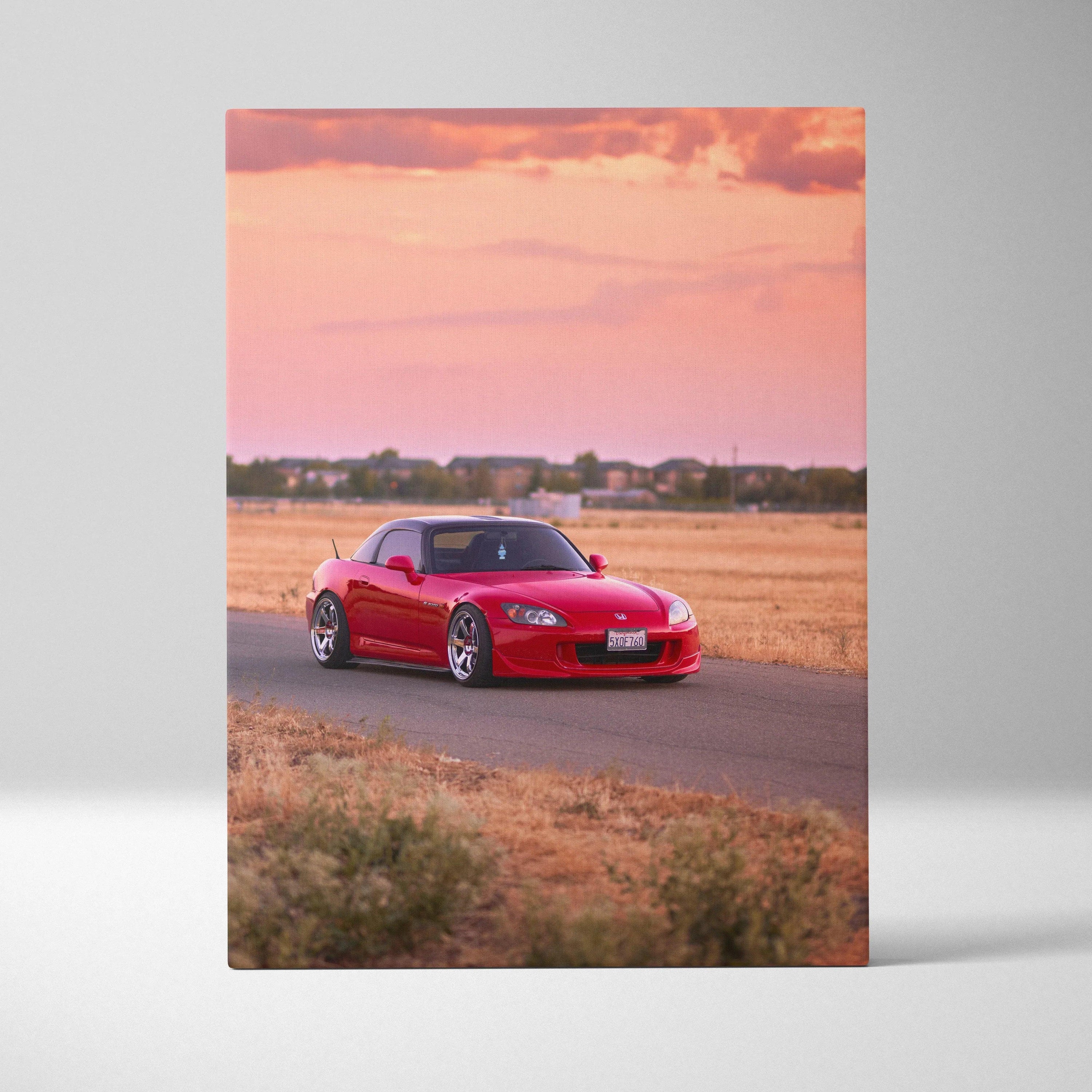 Red Honda S2000 driving on road at sunset canvas wall art in vertical format.