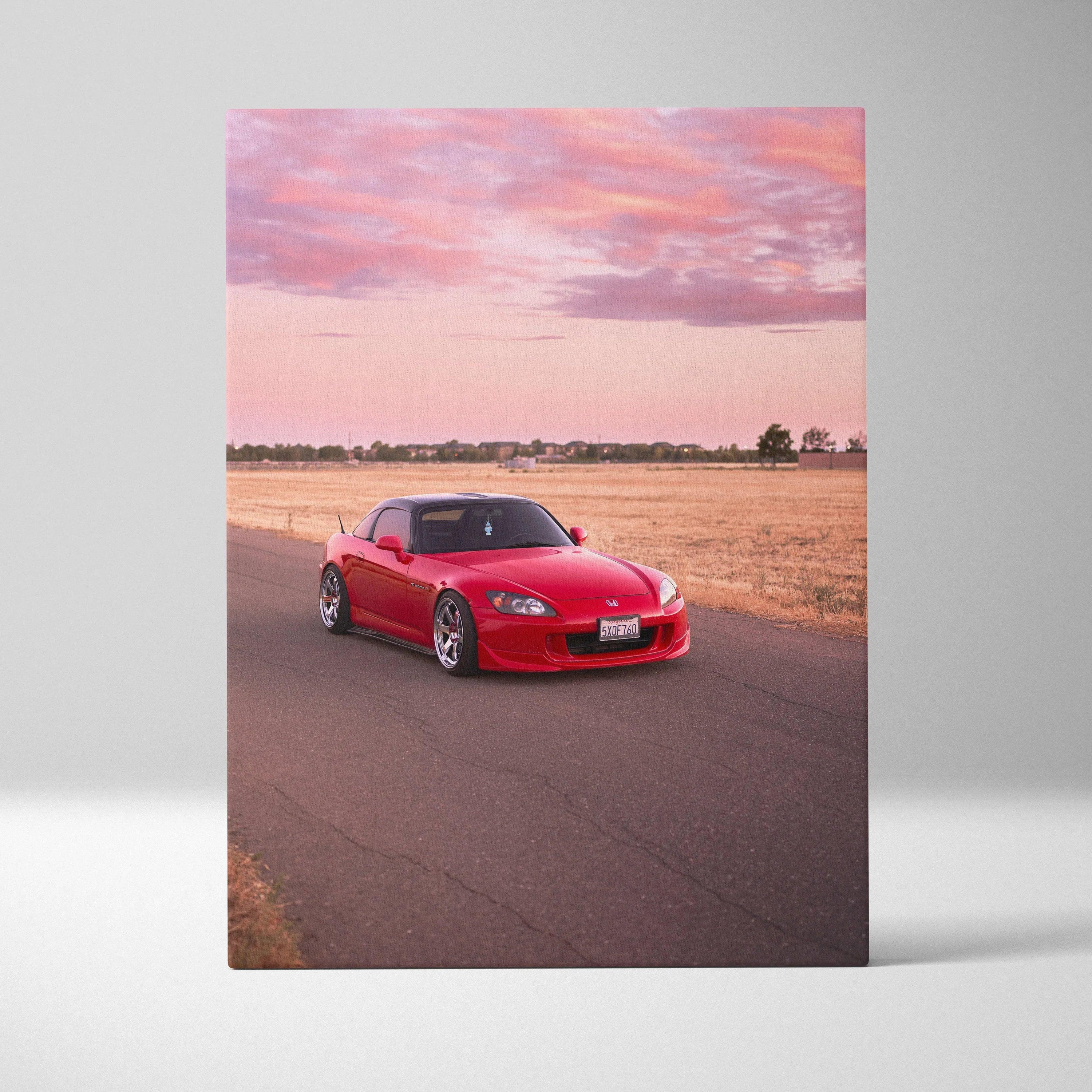 Red Honda S2000 on road at sunset with pink sky vertical canvas wall art.