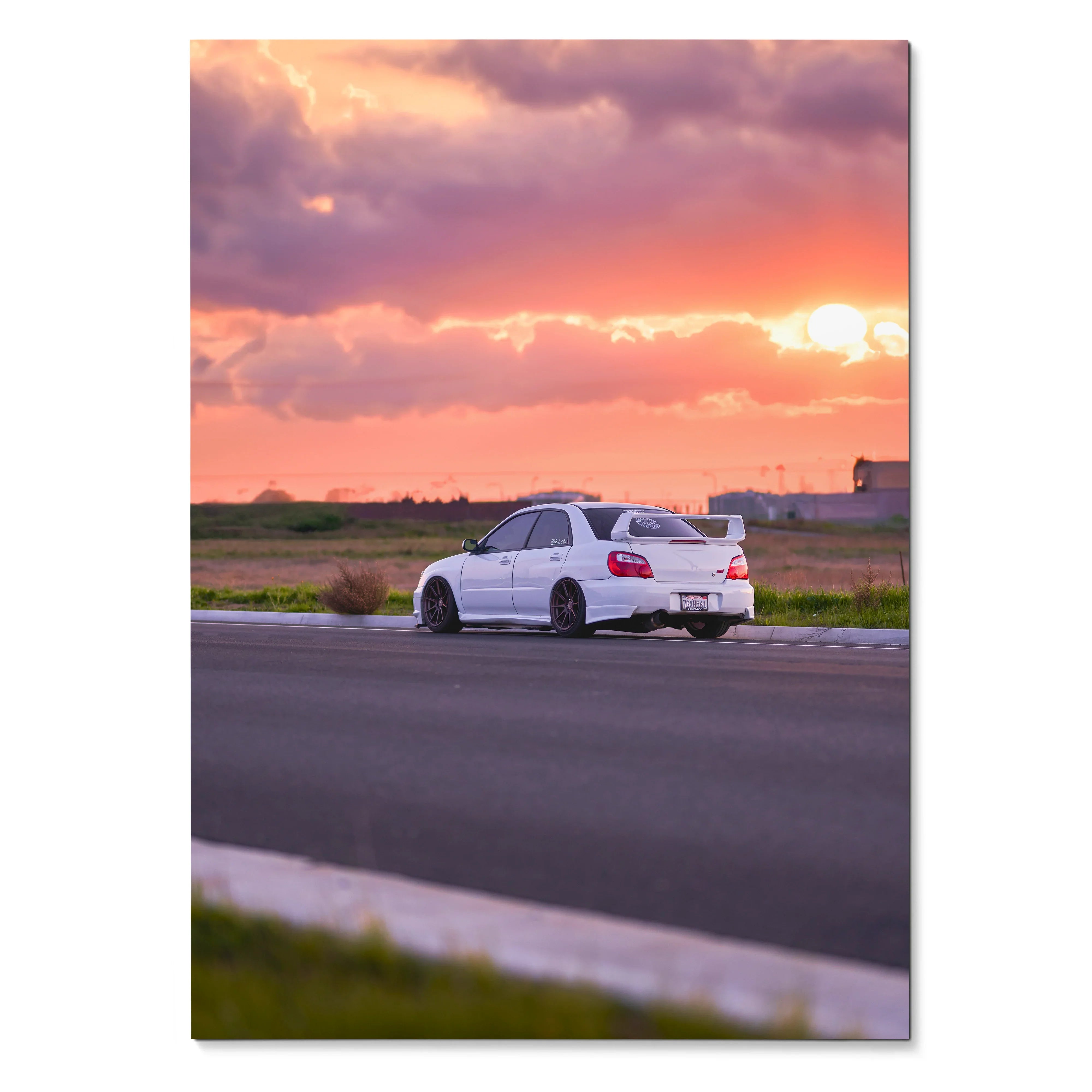 White Subaru WRX STI parked on roadside at vibrant orange and purple sunset poster wall art.