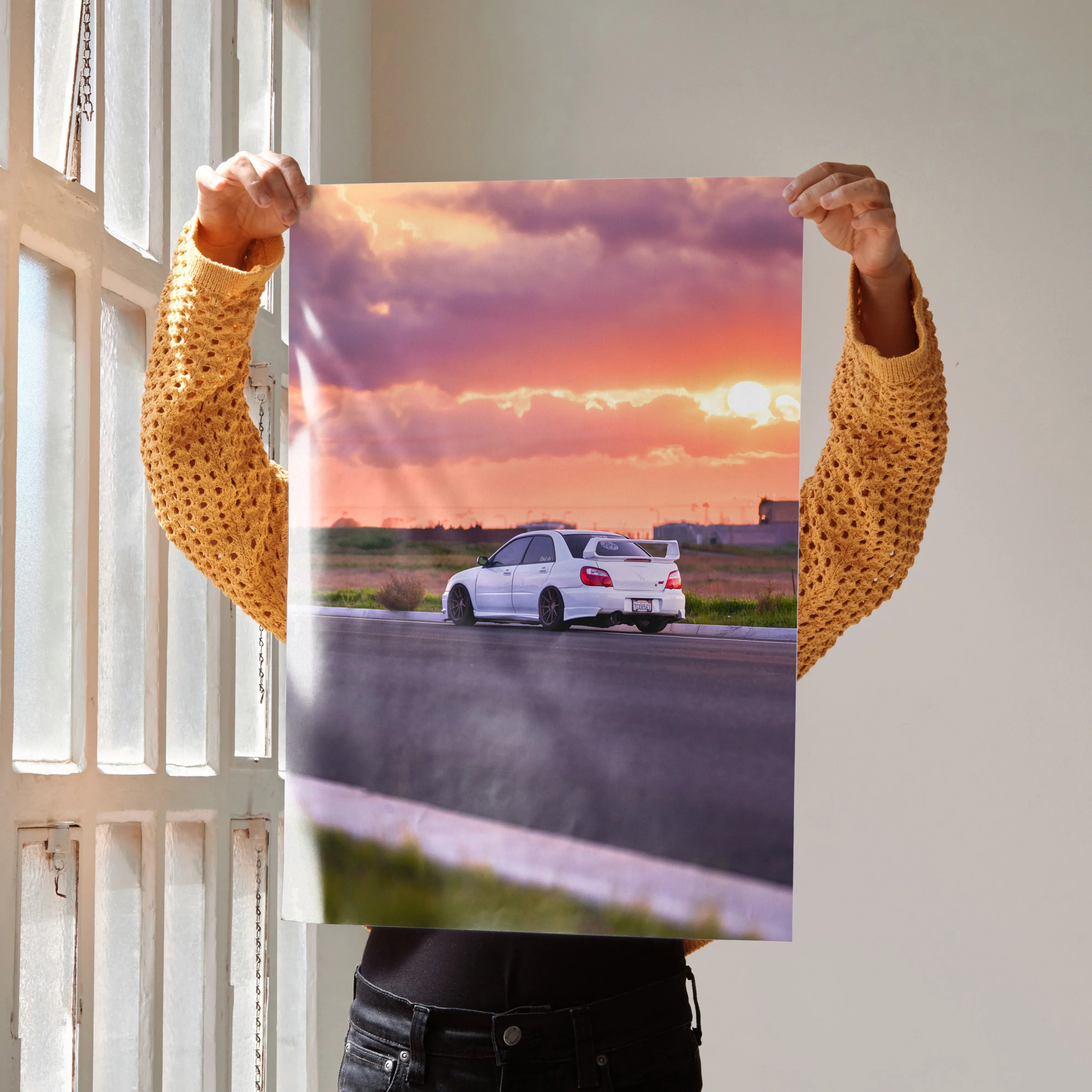 Subaru WRX STI driving on road at sunset poster wall art with vibrant sky colors.