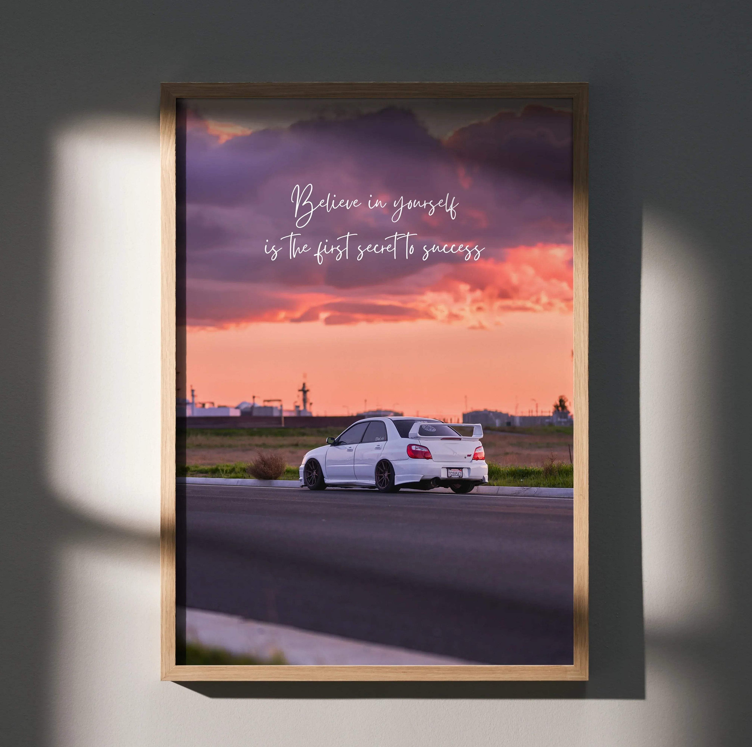 Motivational poster wall art featuring white Subaru WRX STI on rural road at sunset with inspiring text.